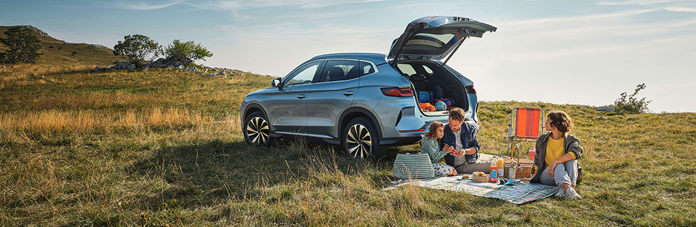 Family sat having a picnic with their BYD SEAL U DM-i in the background Easter holidays